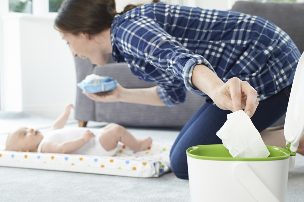 Mother Disposing Of Baby Wipe In Bin