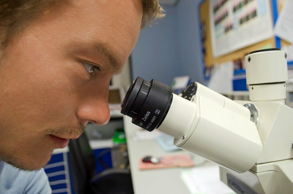 plastic-eating worms featured image: scientist looking under a microscope